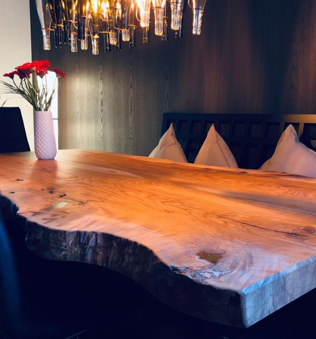 Massive Esche-Tafel mit Baumkante unter warmem Licht
